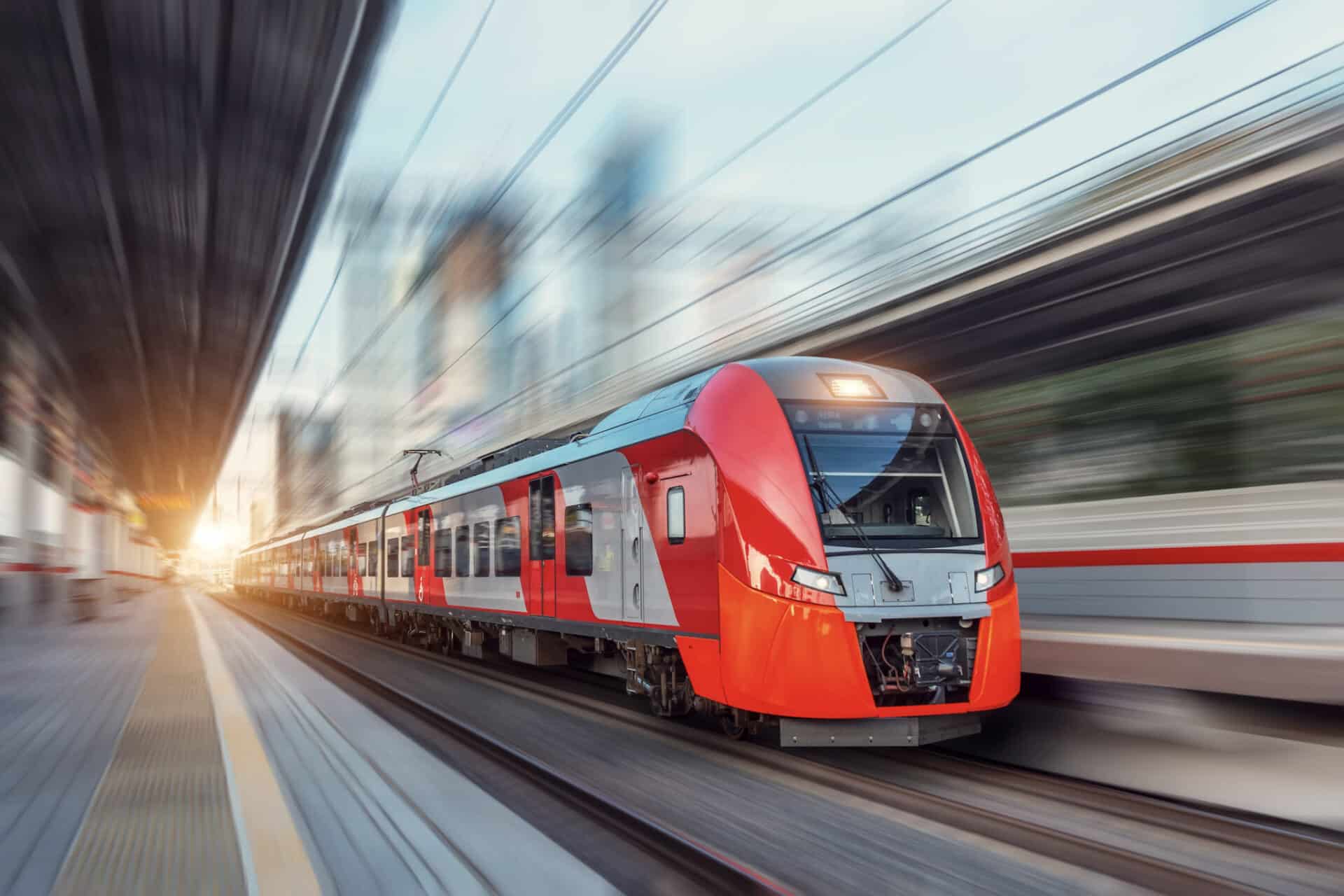 roter Zug fährt durch Bahnhof im Sonnenuntergang als Beispiel für Zulassungen von HANSA-FLEX